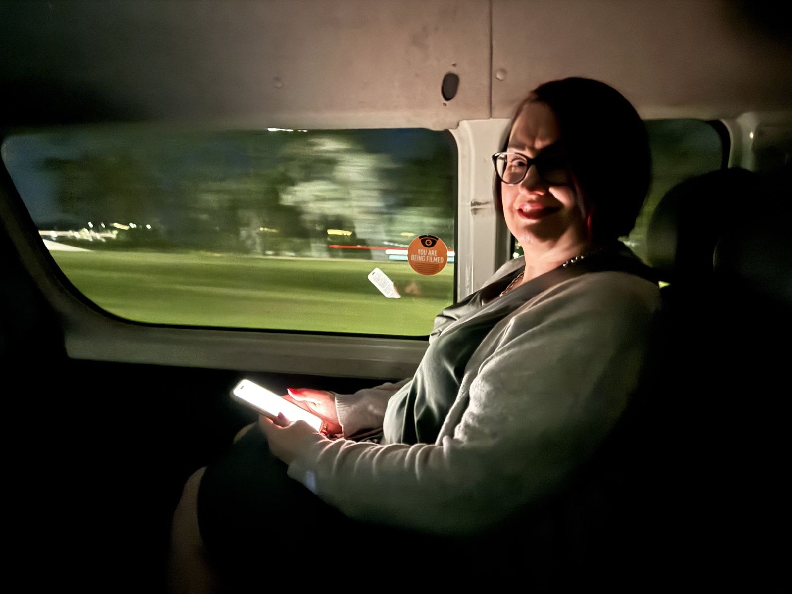 Mardi in the cab on the way to the airport, the glow from her phone eliminate her face she’s smiling excited for the tripahead