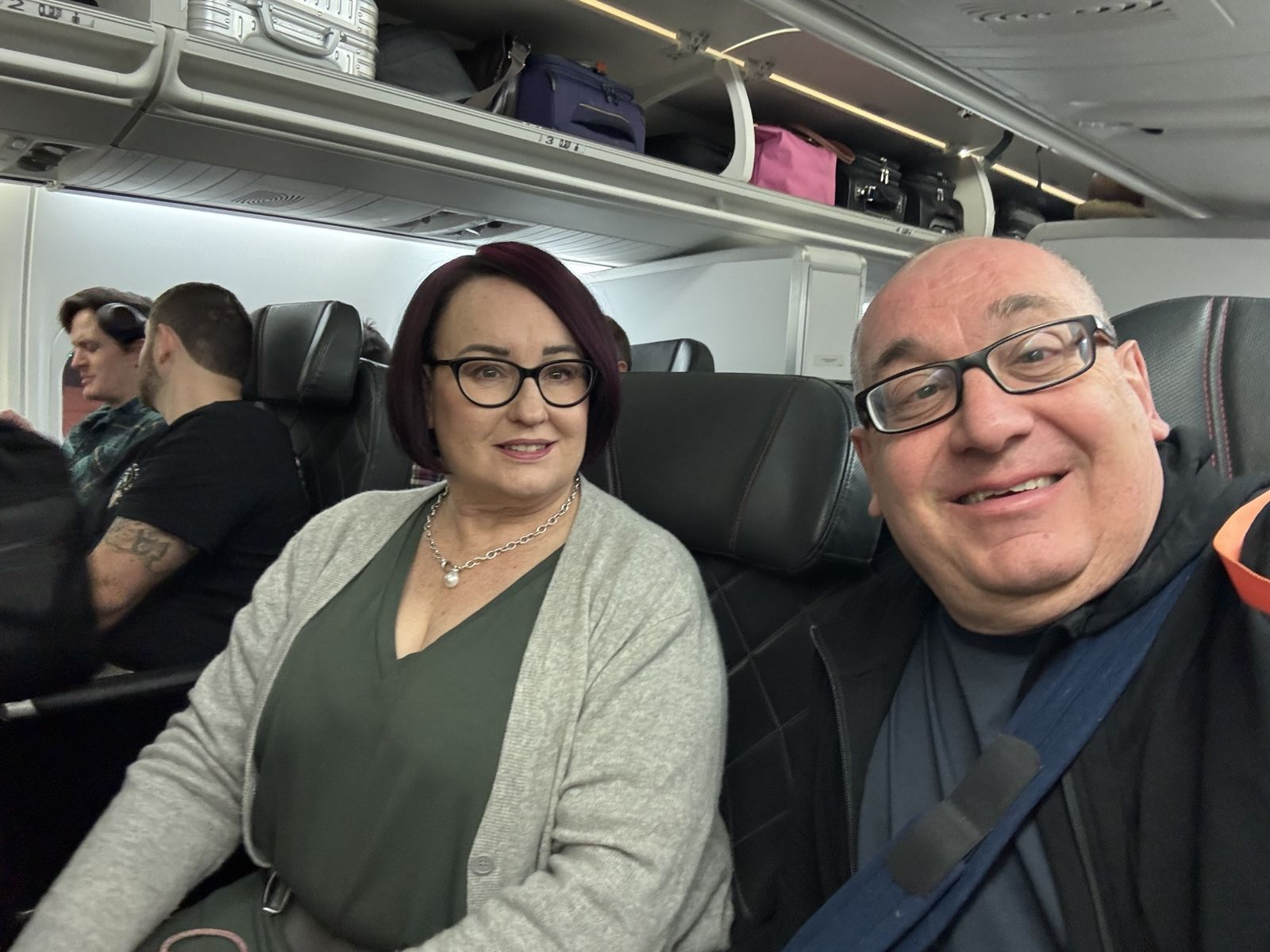 Marty and Michael on the aircraft from Canberra to Sydney :-) Marty and a grey dress and a grey cardigan Michael in a black T-shirt
