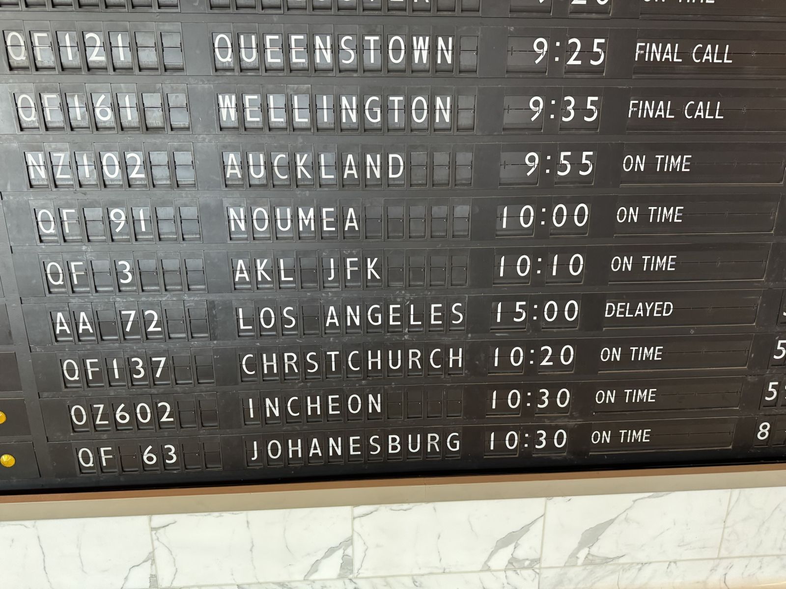 Old style departure board in the Qantas first lounge it shows outside to New York QF three departing at 10:10 am