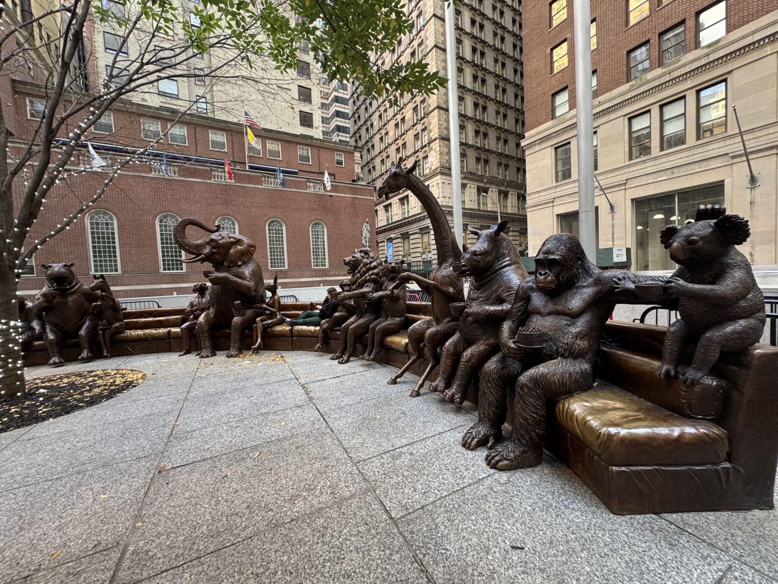 A Gille and Marc sculpture called couch party. A series of animal, dog boom gorilla zebra bear giraffe monkey elephant hippo rhino rabbit sitting on a couch with spaces for people to sit down selfies