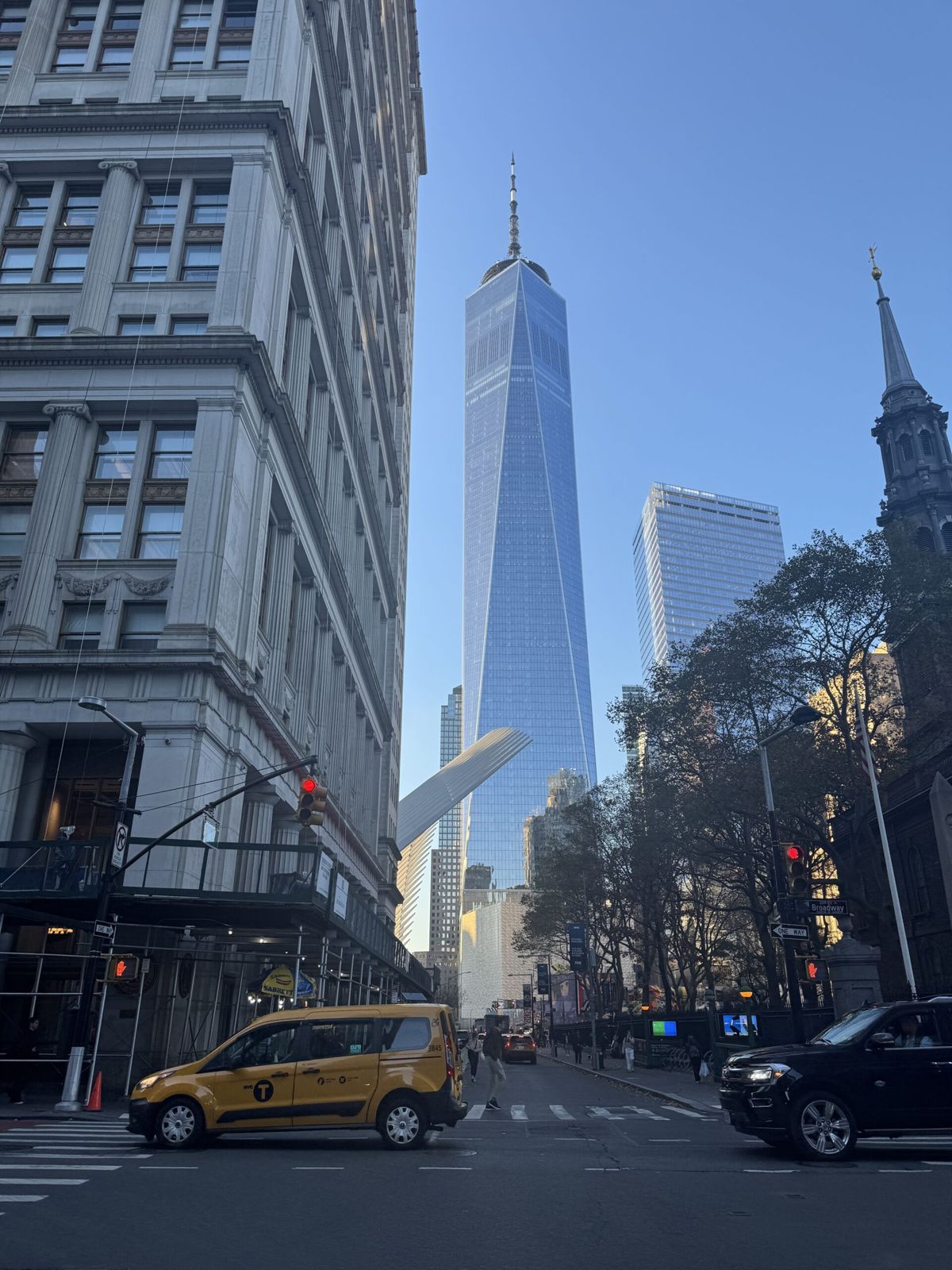 The world trade Centre New York’s tallest building framed by buildings in the foreground. They are in shadow but the World Trade Centre is in full sunlight with a blue sky.