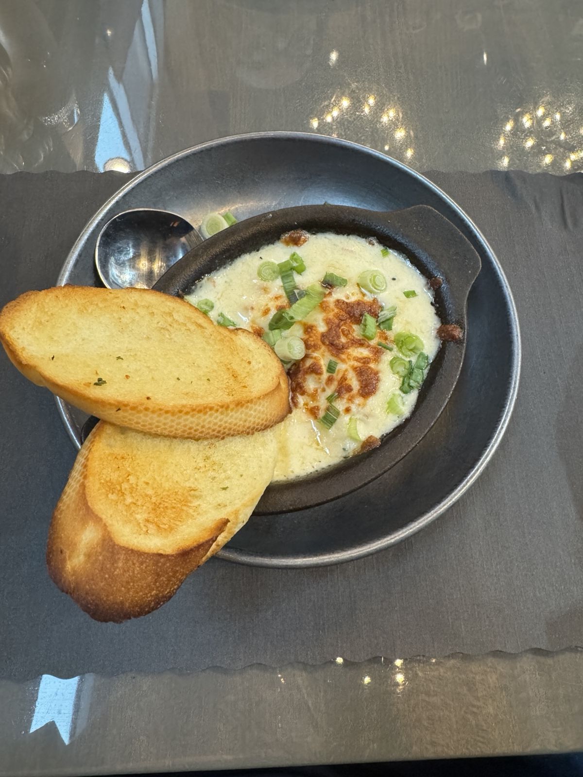 Seafood chowder. A dish with colourful liquid, the chowder and to oval shaped pieces of toast