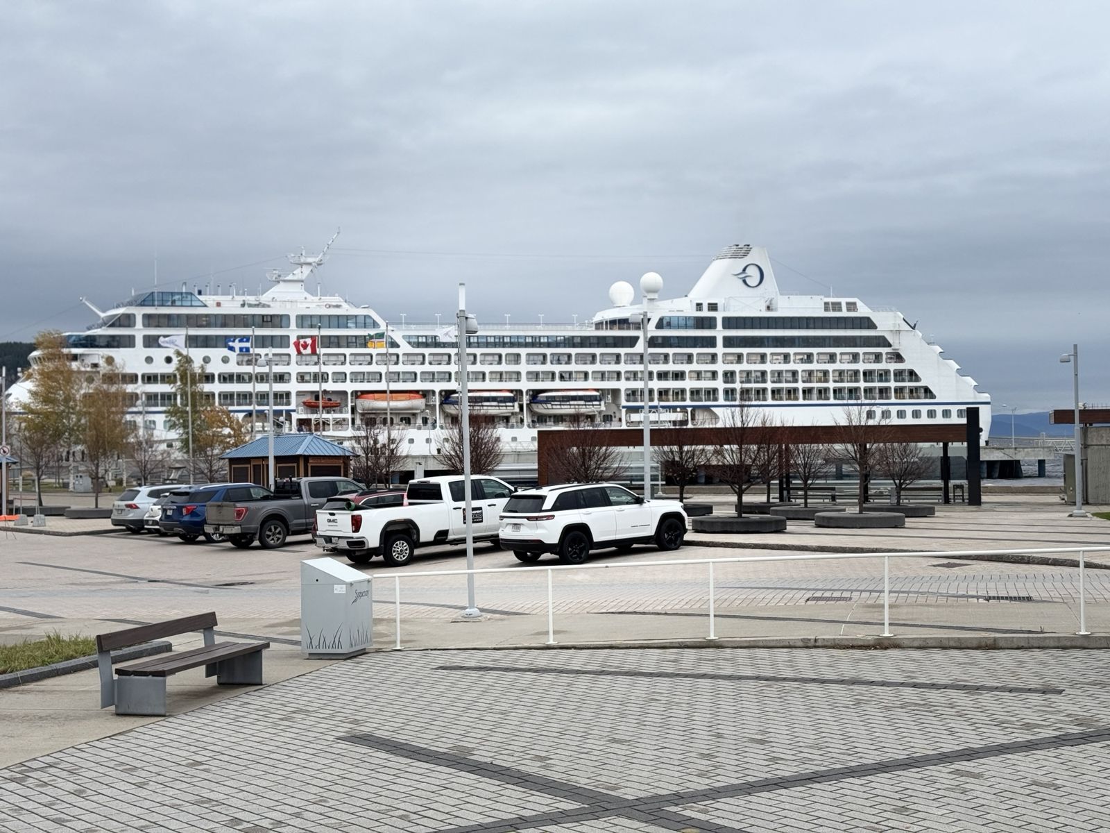 Our ship from a distance. In the foreground a car park with large utes. 